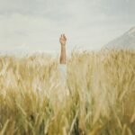 person in white shorts standing on brown grass field during daytime